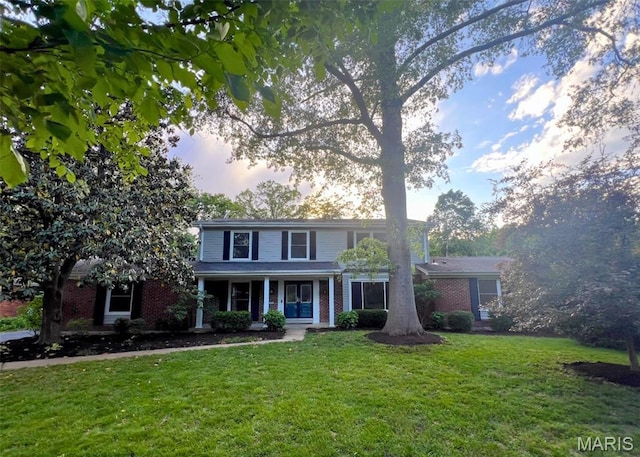 173 Portico Dr, Chesterfield, MO 63017 - traditional-style home featuring brick siding, a front yard, and a porch