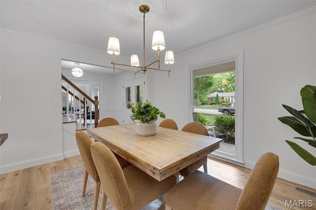 173 Portico Dr, Chesterfield, MO 63017 - dining space with stairway, light wood-type flooring, crown molding, baseboards, and a chandelier