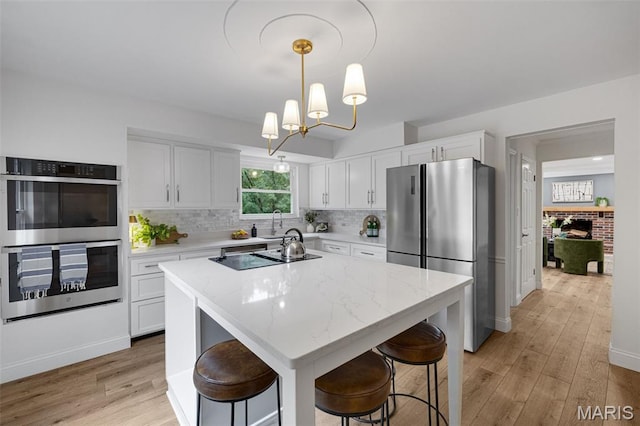 173 Portico Dr, Chesterfield, MO 63017 - kitchen featuring stainless steel appliances, light wood-style flooring, and white cabinets