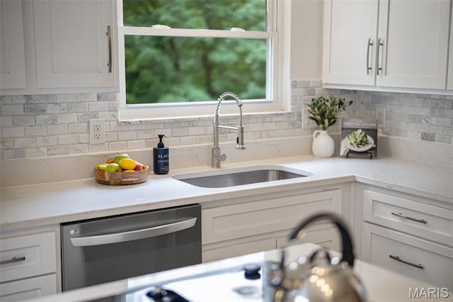 173 Portico Dr, Chesterfield, MO 63017 - kitchen with stainless steel dishwasher, a sink, white cabinets, tasteful backsplash, and light stone countertops