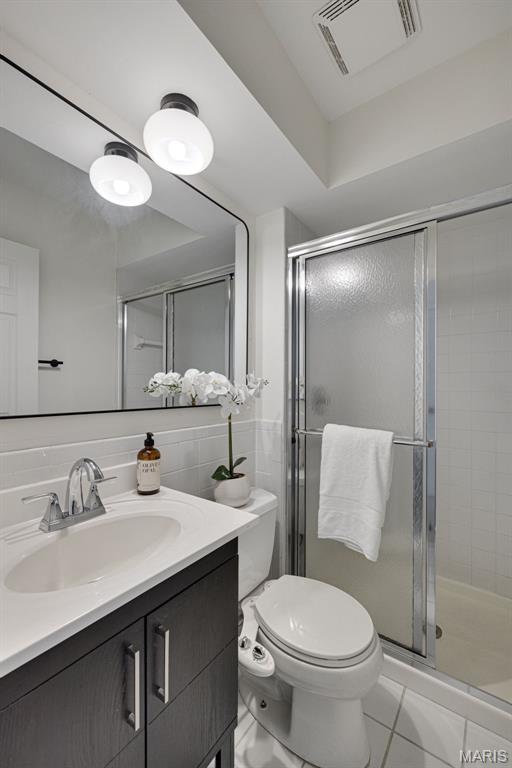 173 Portico Dr, Chesterfield, MO 63017 - full bathroom featuring vanity, toilet, a stall shower, and tile walls