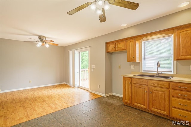 1804 Meadow Ct, Rolla, MO 65401 - kitchen featuring a sink, ceiling fan, light countertops, baseboards, and brown cabinetry