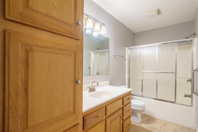 1804 Meadow Ct, Rolla, MO 65401 - bathroom featuring vanity, toilet, bath / shower combo with glass door, and tile patterned flooring