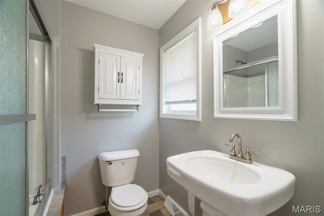 1804 Meadow Ct, Rolla, MO 65401 - bathroom featuring a sink, baseboards, a shower, and toilet