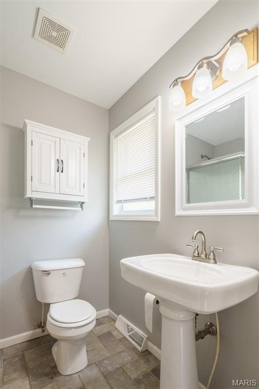1804 Meadow Ct, Rolla, MO 65401 - bathroom featuring baseboards, toilet, stone finish flooring, and a shower