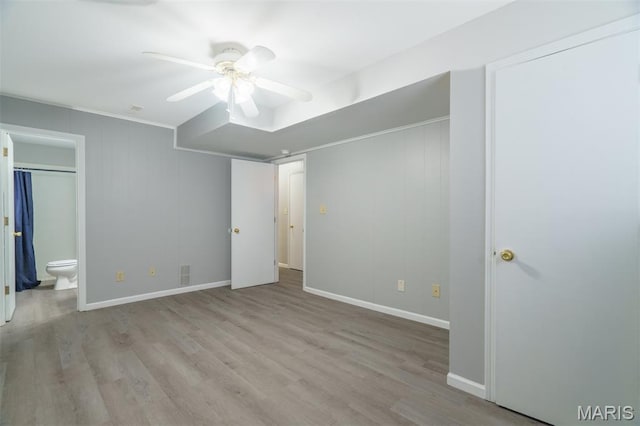 1804 Meadow Ct, Rolla, MO 65401 - unfurnished bedroom with wood finished floors, baseboards, ensuite bath, and a ceiling fan