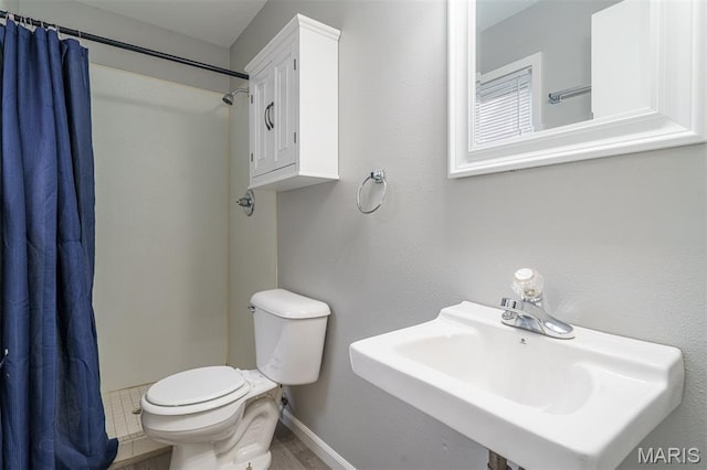 1804 Meadow Ct, Rolla, MO 65401 - bathroom featuring toilet, a sink, curtained shower, and baseboards
