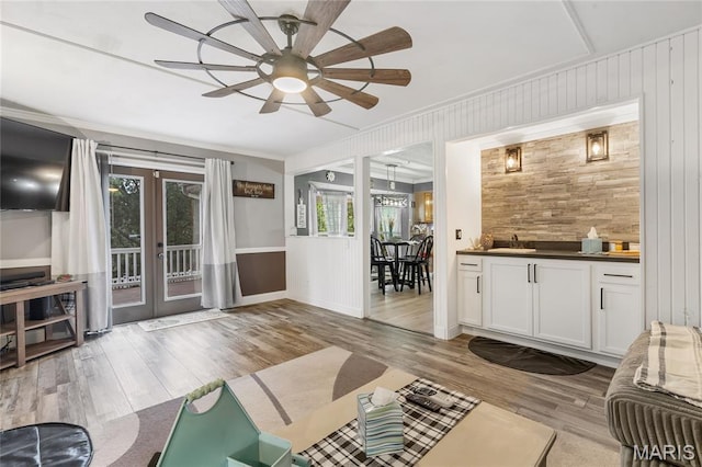 116 Shirewood Dr, Saint Charles, MO 63303 - living room with wood finished floors, a ceiling fan, wood walls, french doors, and ornamental molding