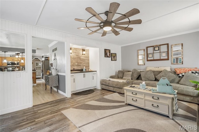 116 Shirewood Dr, Saint Charles, MO 63303 - living area featuring ornamental molding, a ceiling fan, wood finished floors, and arched walkways