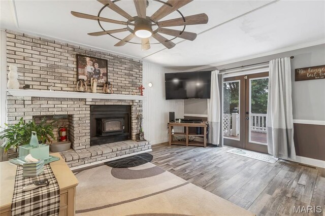 116 Shirewood Dr, Saint Charles, MO 63303 - living room featuring french doors, ornamental molding, ceiling fan, wood finished floors, and a wood stove