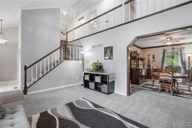 116 Shirewood Dr, Saint Charles, MO 63303 - carpeted living room with crown molding, stairway, a ceiling fan, a towering ceiling, and arched walkways