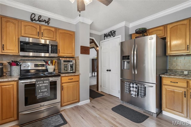 116 Shirewood Dr, Saint Charles, MO 63303 - kitchen with appliances with stainless steel finishes, decorative backsplash, a ceiling fan, light wood finished floors, and ornamental molding