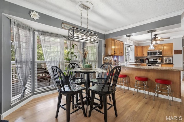 116 Shirewood Dr, Saint Charles, MO 63303 - dining area featuring crown molding, a textured ceiling, light wood-type flooring, and ceiling fan