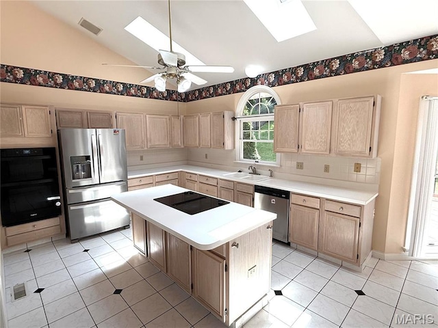 720 Woodridge Heights Ct, Manchester, MO 63011 - kitchen featuring black appliances, a skylight, light brown cabinetry, and vaulted ceiling