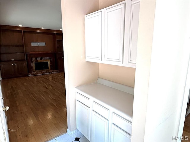 720 Woodridge Heights Ct, Manchester, MO 63011 - kitchen with white cabinets, light wood finished floors, light countertops, and a fireplace