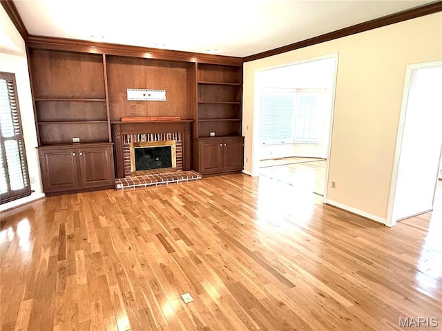 720 Woodridge Heights Ct, Manchester, MO 63011 - unfurnished living room featuring crown molding, light wood-style flooring, built in shelves, and a fireplace