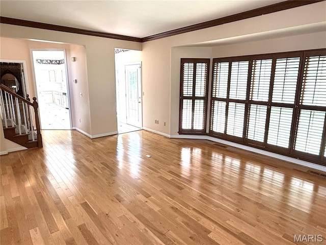 720 Woodridge Heights Ct, Manchester, MO 63011 - unfurnished living room featuring stairs, light wood-style floors, and crown molding