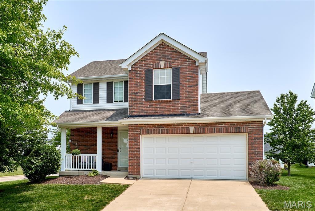 228 Centerfield Dr, Ofallon, MO 63366 - traditional-style house with concrete driveway, brick siding, covered porch, and a shingled roof