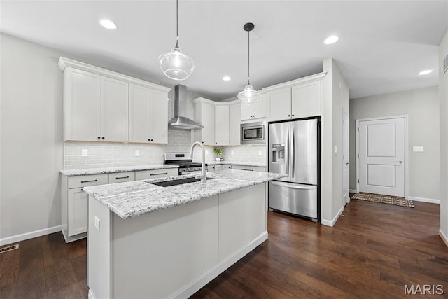 14 Ivyleigh Ct, Saint Charles, MO 63303 - kitchen with appliances with stainless steel finishes, wall chimney exhaust hood, backsplash, a center island with sink, and dark wood-type flooring