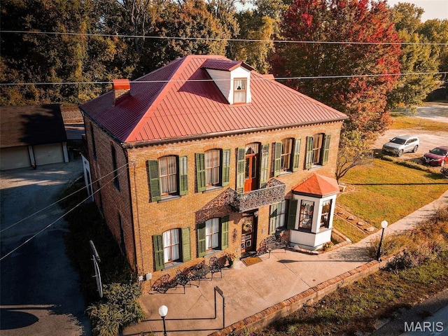 415 E 1st St, Hermann, MO 65041 - view of front facade featuring brick siding, a metal roof, an outdoor structure, a chimney, and a standing seam roof