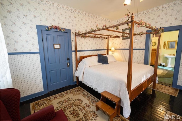 415 E 1st St, Hermann, MO 65041 - bedroom featuring wallpapered walls, hardwood / wood-style floors, and connected bathroom