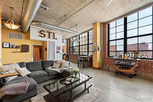 2323 Locust St Unit 308, Saint Louis, MO 63103 - living area with brick wall, finished concrete flooring, and a towering ceiling