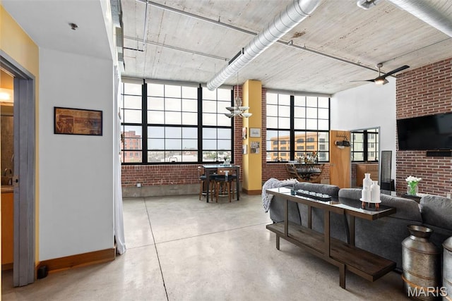 2323 Locust St Unit 308, Saint Louis, MO 63103 - living room with baseboards, brick wall, finished concrete flooring, and ceiling fan