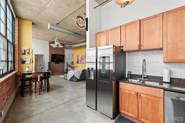 2323 Locust St Unit 308, Saint Louis, MO 63103 - kitchen with stainless steel appliances, a sink, decorative backsplash, concrete floors, and dark stone countertops