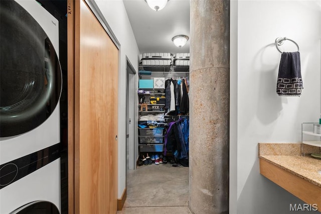 2323 Locust St Unit 308, Saint Louis, MO 63103 - bathroom featuring stacked washing machine and dryer, concrete flooring, and a spacious closet