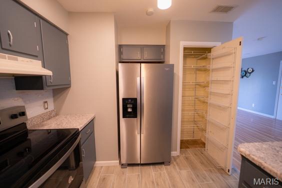 9145 Villaridge Ct H, Unit H, MO 63123 - kitchen featuring appliances with stainless steel finishes, under cabinet range hood, gray cabinetry, and light wood-style flooring
