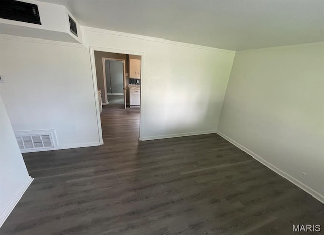 unfurnished room with baseboards and dark wood-style flooring