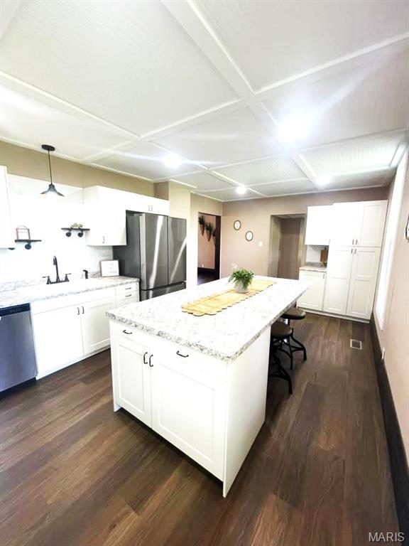 10216 High St, Belgrade, MO 63622 - kitchen featuring appliances with stainless steel finishes, dark wood-type flooring, coffered ceiling, white cabinets, and light stone counters