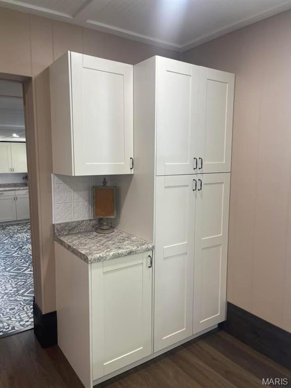 10216 High St, Belgrade, MO 63622 - kitchen with dark wood-style flooring, white cabinets, and light stone counters