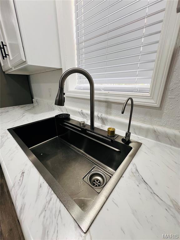 403 E Summit St, Doniphan, MO 63935 - kitchen view of a sink, light stone counters, and white cabinetry