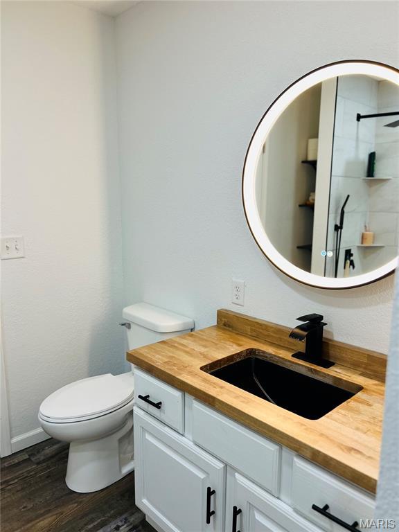 403 E Summit St, Doniphan, MO 63935 - full bathroom featuring vanity, toilet, wood finished floors, and a tile shower
