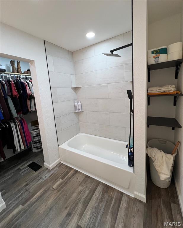 403 E Summit St, Doniphan, MO 63935 - full bathroom with wood finished floors, washtub / shower combination, baseboards, a spacious closet, and recessed lighting