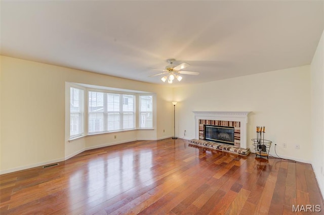 12118 Fahrpark Ln, Saint Louis, MO 63146 - unfurnished living room featuring ceiling fan, wood finished floors, a fireplace, and baseboards