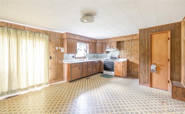 18795 S US Highway 63, Rolla, MO 65401 - kitchen featuring white range oven, wood walls, light countertops, and brown cabinetry