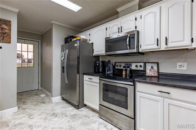 108 Karen St, Sikeston, MO 63801 - kitchen featuring stainless steel appliances, ornamental molding, dark countertops, baseboards, and white cabinets