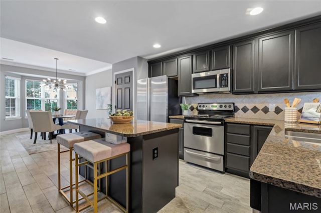 231 W Monroe Ave Unit 205, Saint Louis, MO 63122 - kitchen featuring stainless steel appliances, backsplash, a chandelier, stone counters, and a breakfast bar
