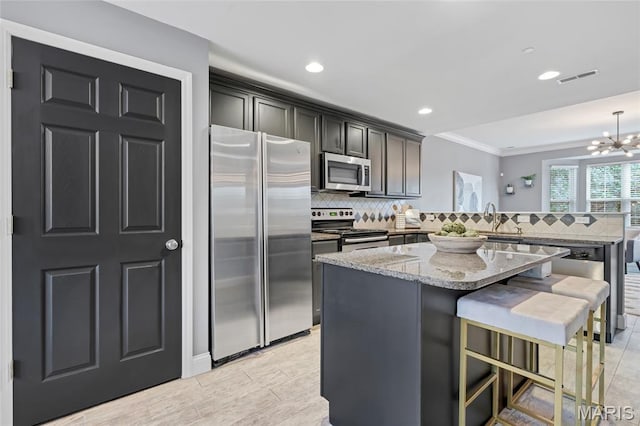 231 W Monroe Ave Unit 205, Saint Louis, MO 63122 - kitchen with stainless steel appliances, a peninsula, crown molding, backsplash, and light stone countertops