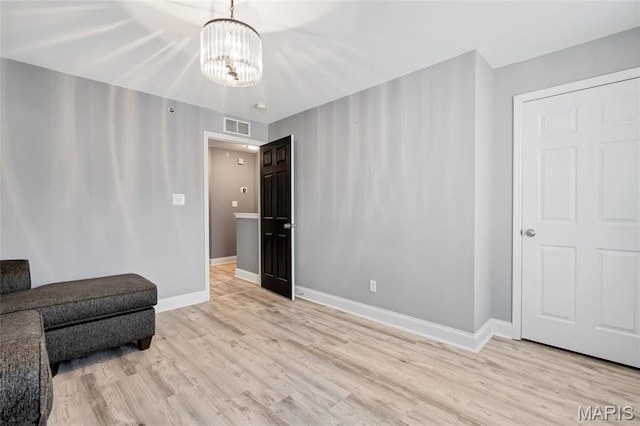 231 W Monroe Ave Unit 205, Saint Louis, MO 63122 - unfurnished living room with light wood-type flooring and a chandelier