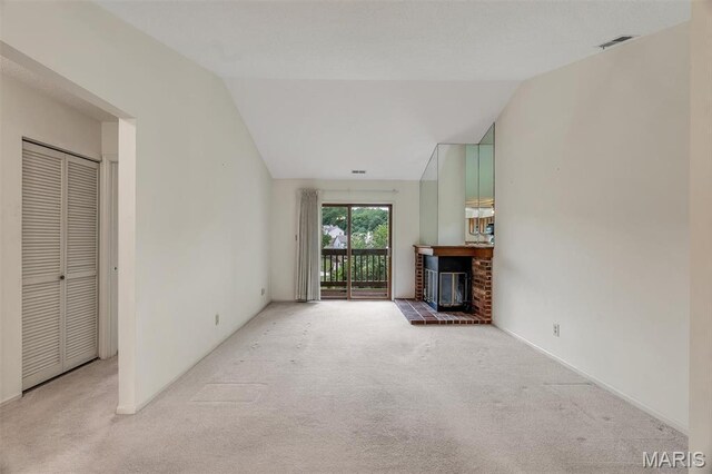 2303 Yosemite Park Ct Unit E, Maryland Heights, MO 63043 - unfurnished living room featuring carpet, lofted ceiling, and a fireplace