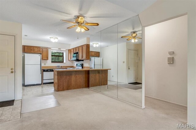 2303 Yosemite Park Ct Unit E, Maryland Heights, MO 63043 - kitchen featuring white appliances, brown cabinetry, ceiling fan, light countertops, and a textured ceiling
