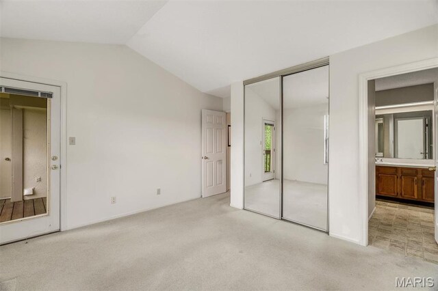 2303 Yosemite Park Ct Unit E, Maryland Heights, MO 63043 - unfurnished bedroom featuring light carpet, vaulted ceiling, a closet, and ensuite bath