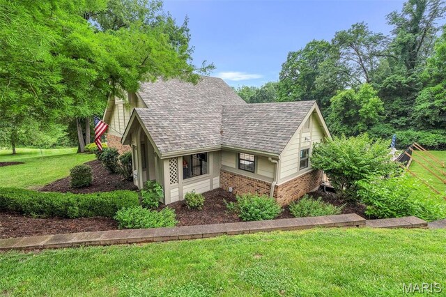 2303 Yosemite Park Ct Unit E, Maryland Heights, MO 63043 - view of property exterior with brick siding, a yard, and a shingled roof
