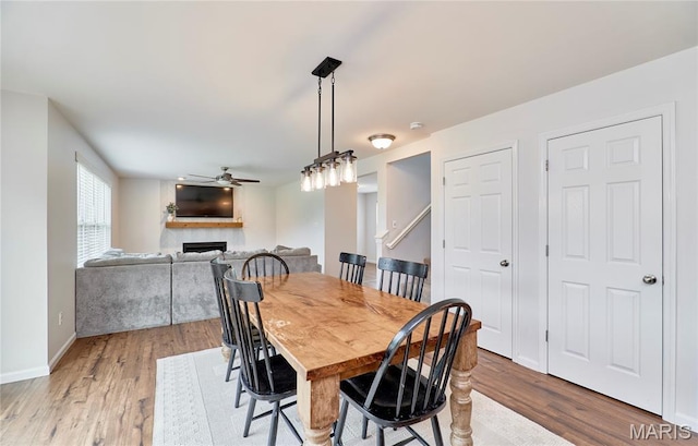 2907 Preston Woods Trl, Lake St Louis, MO 63367 - dining space with a ceiling fan, wood finished floors, and a fireplace