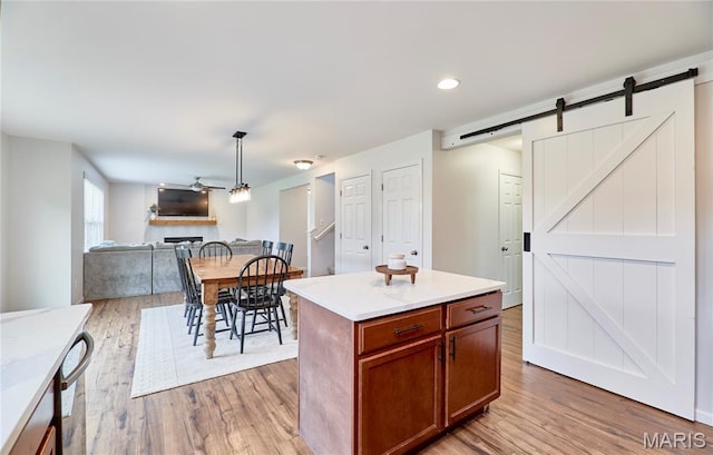 2907 Preston Woods Trl, Lake St Louis, MO 63367 - kitchen with a barn door, wood finished floors, open floor plan, ceiling fan, and recessed lighting