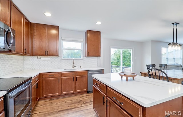 2907 Preston Woods Trl, Lake St Louis, MO 63367 - kitchen with stainless steel appliances, light wood-style floors, brown cabinetry, and recessed lighting