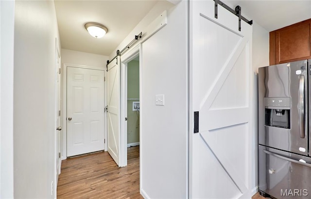 2907 Preston Woods Trl, Lake St Louis, MO 63367 - hallway with a barn door and light wood-style flooring